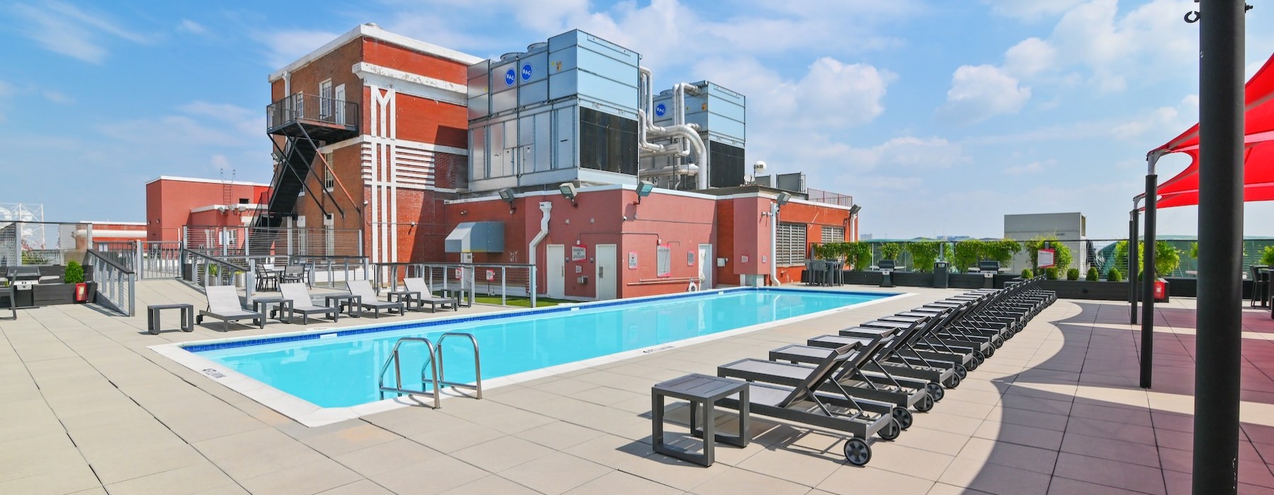 a swimming pool with chairs and a building in the background