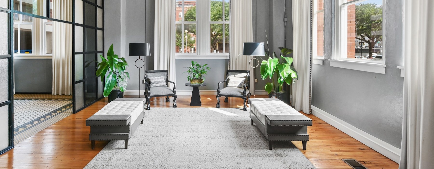 a room with a large window and a couch and chairs